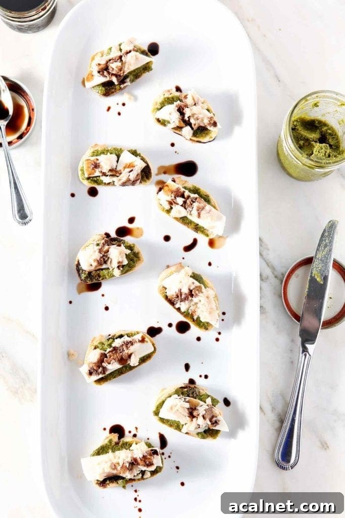 overhead photo of tuna pesto crostini on a white serving tray
