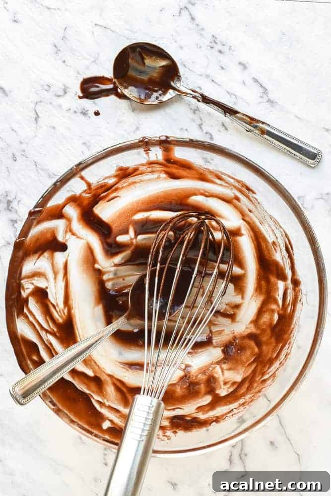Scraped bowl, whisk and spoons after preparing chocolate pudding recipe viewed from above