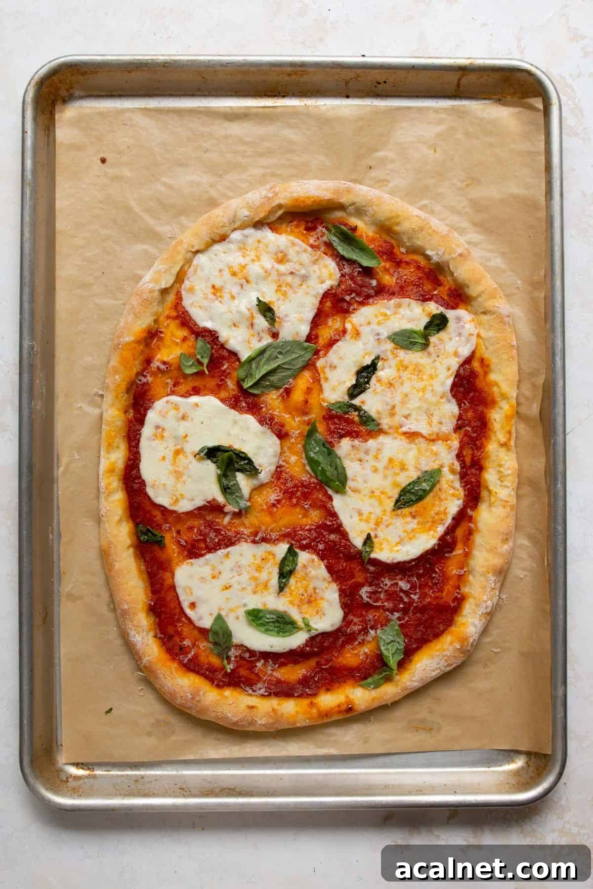 Homemade Greek Yogurt Pizza Dough: Soft, Quick Recipe 12 Margherita-style Greek Yogurt Pizza baking on a hot sheet pan until the crust turns golden.
