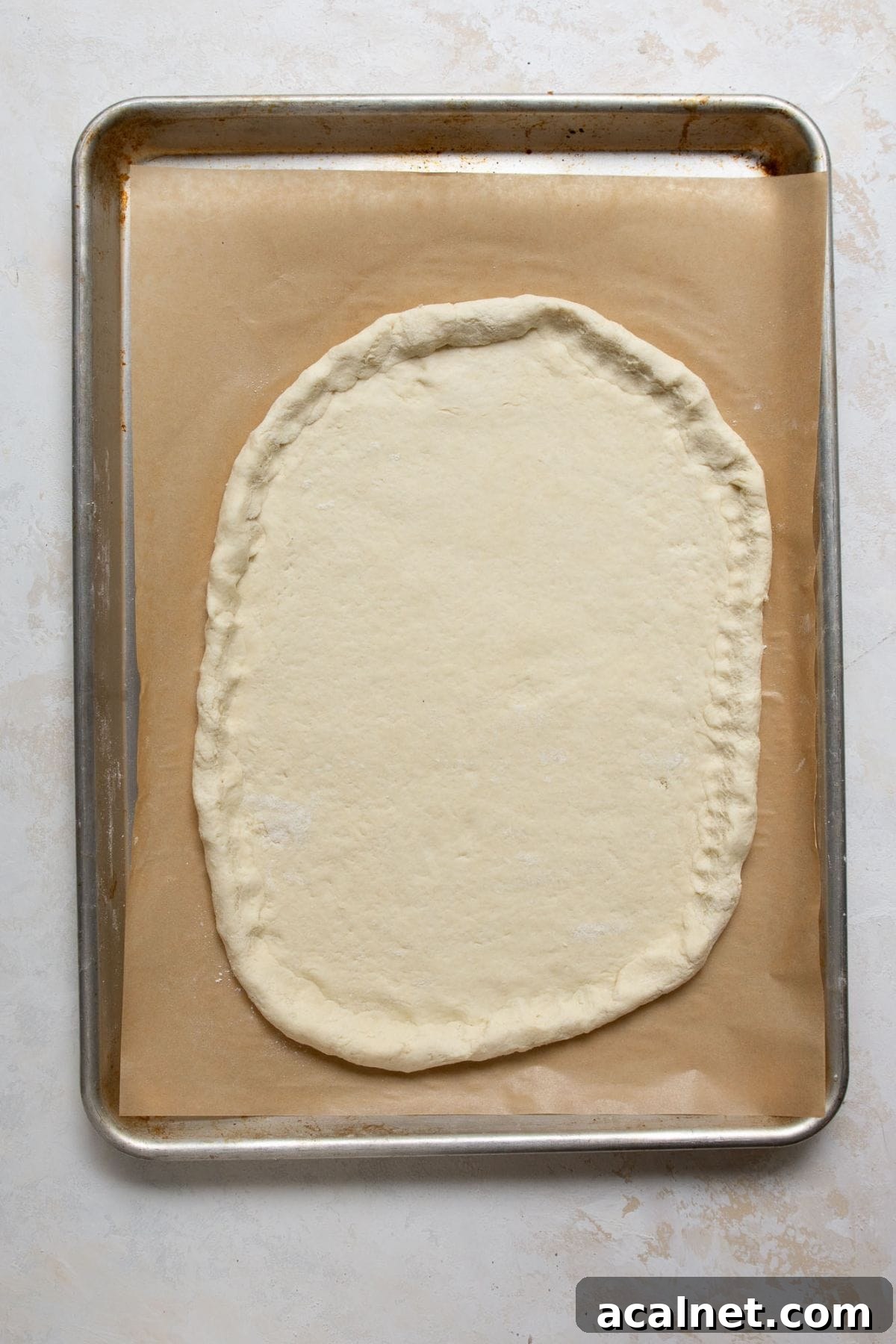 Homemade Greek Yogurt Pizza Dough: Soft, Quick Recipe 9 Greek Yogurt Pizza Dough shaped with a crust edge on a parchment-lined baking sheet.