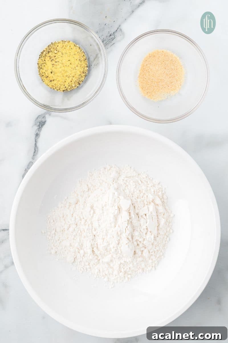 A bowl of flour, lemon pepper, and garlic powder.