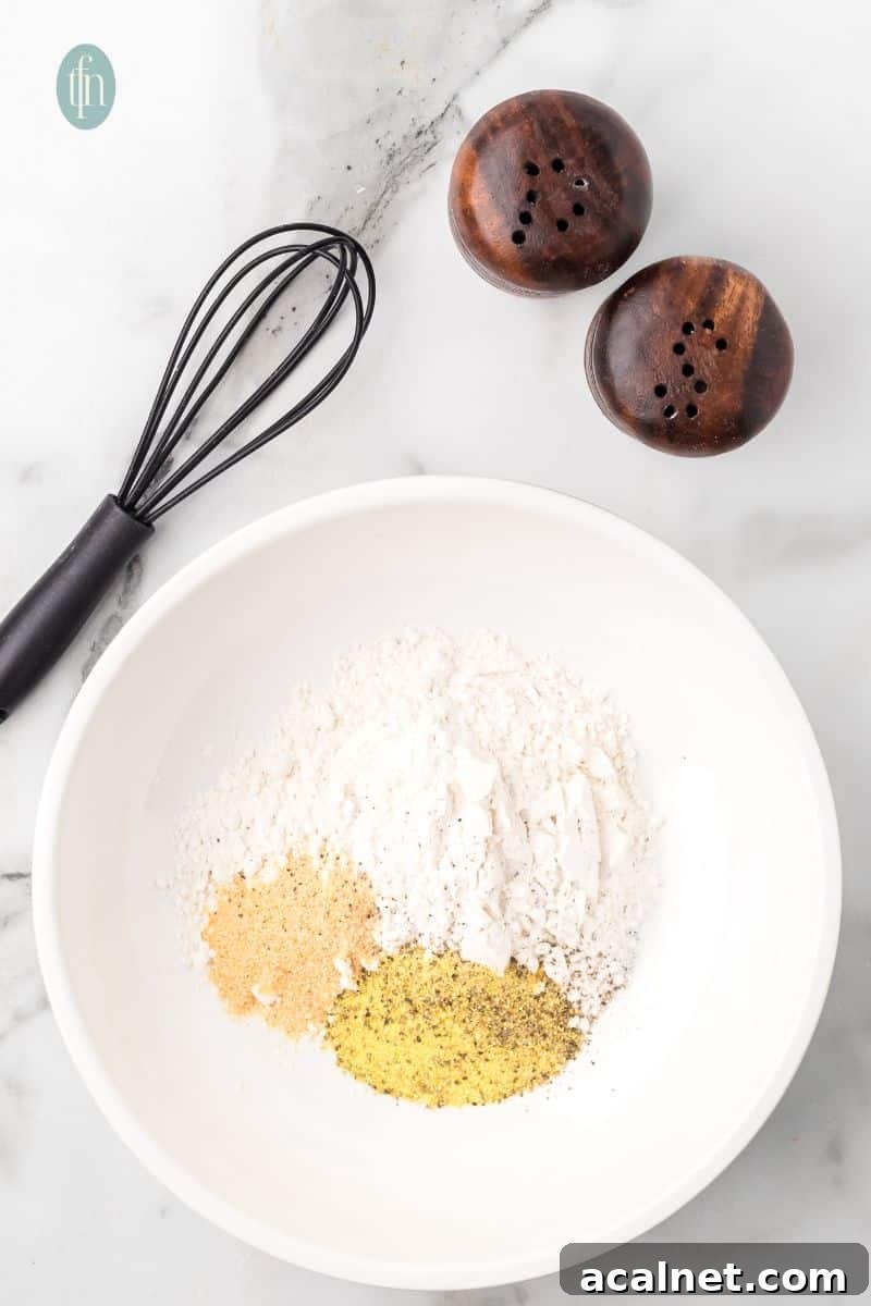 A bowl of powdered ingredients, salt and pepper shaker, and a whisk.