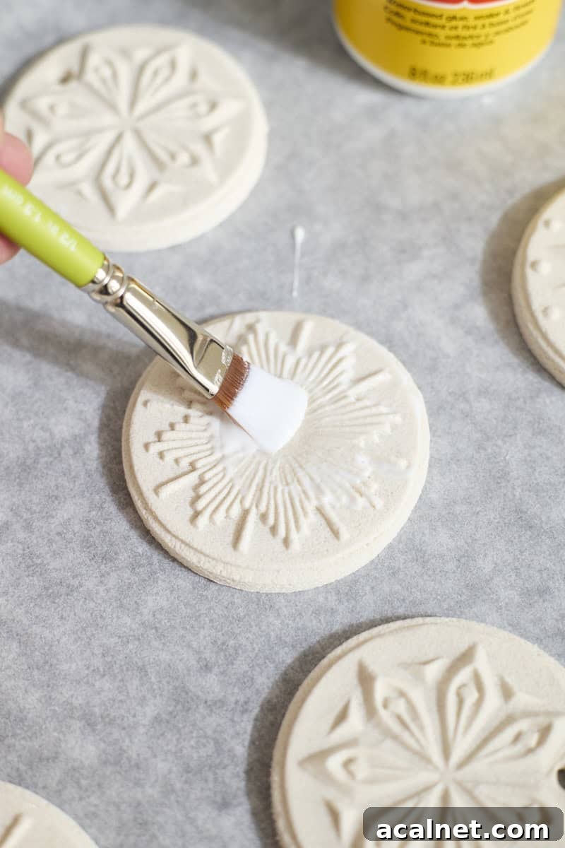 An ornament being brushed with Mod Podge.