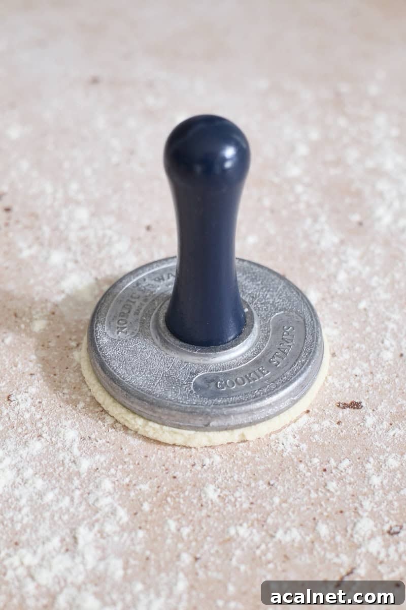 A cookie stamp pressing down on the dough.