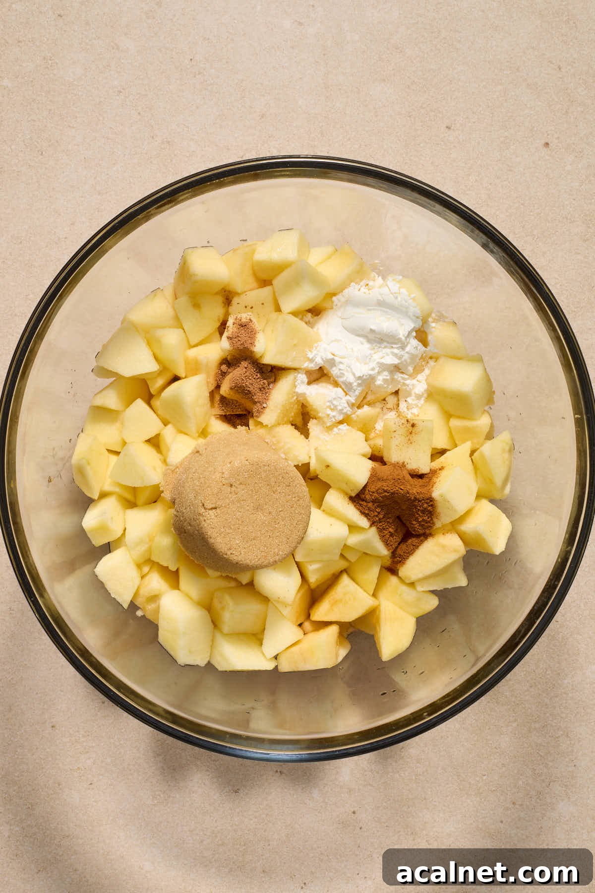 Chopped apples and other filling ingredients in a large glass bowl.