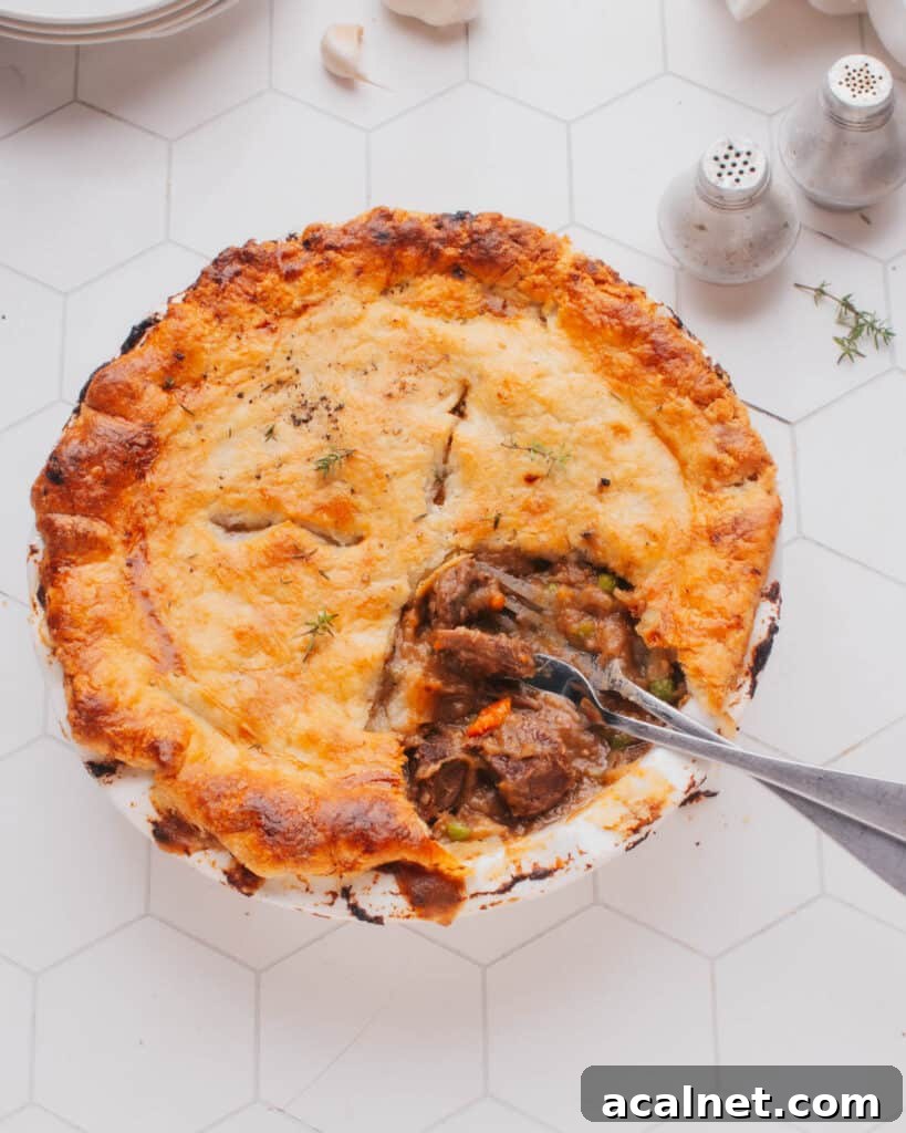 Classic Beef Pot Pie with Flaky Pastry Crust 2 Beef Pot Pie with a piece removed and two forks.