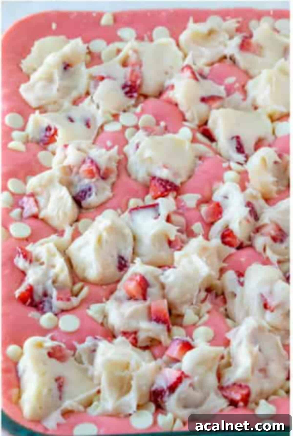 Strawberry earthquake cake topped with white chocolate and strawberries before baking.