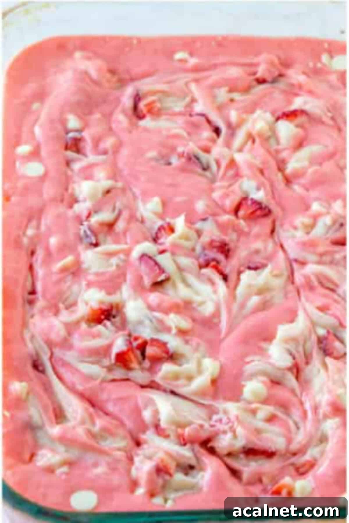 Baked strawberry earthquake cake with a pink and white cheesecake swirl in the dish.