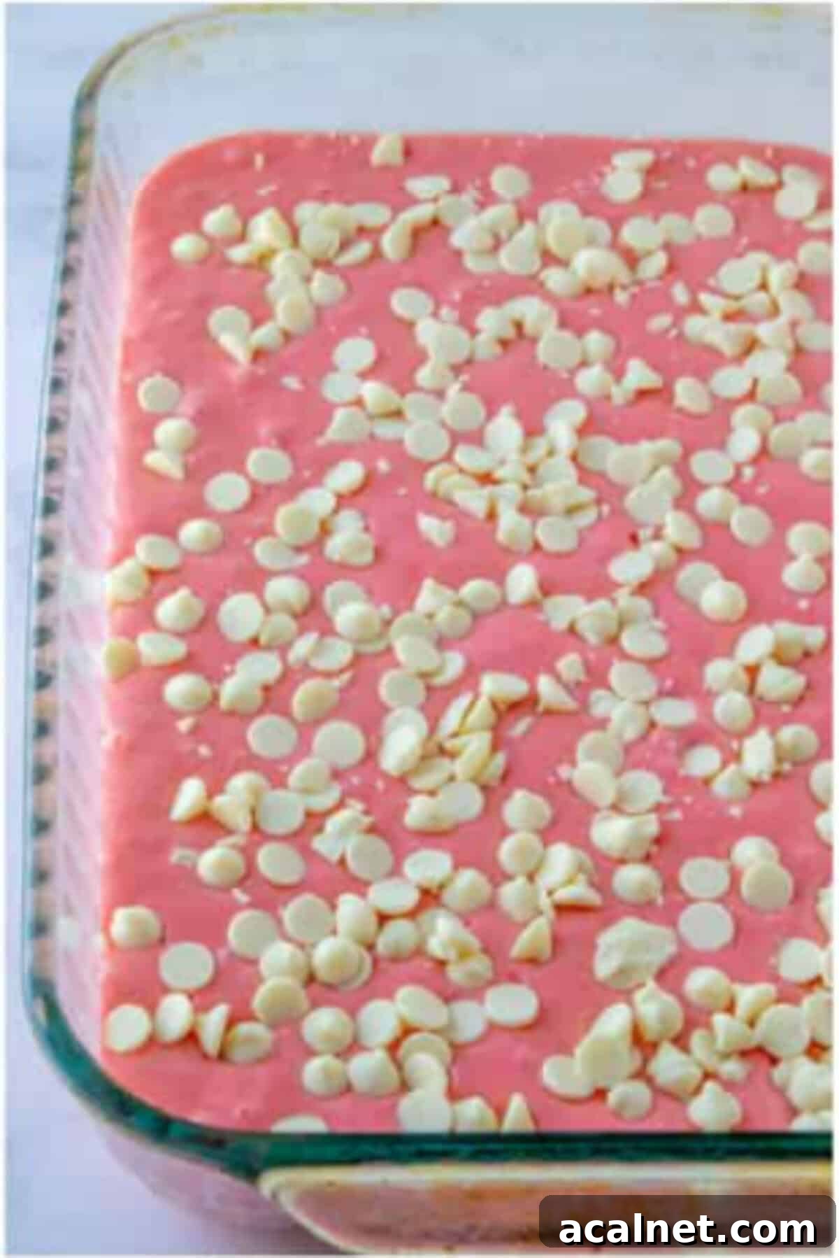 Strawberry cake batter topped with white chocolate chips.