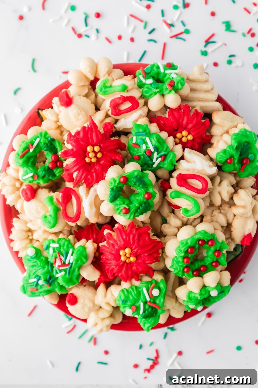 Classic Christmas Spritz Cookie Recipe 15 plate with spritzer cookies on it and sprinkles around it