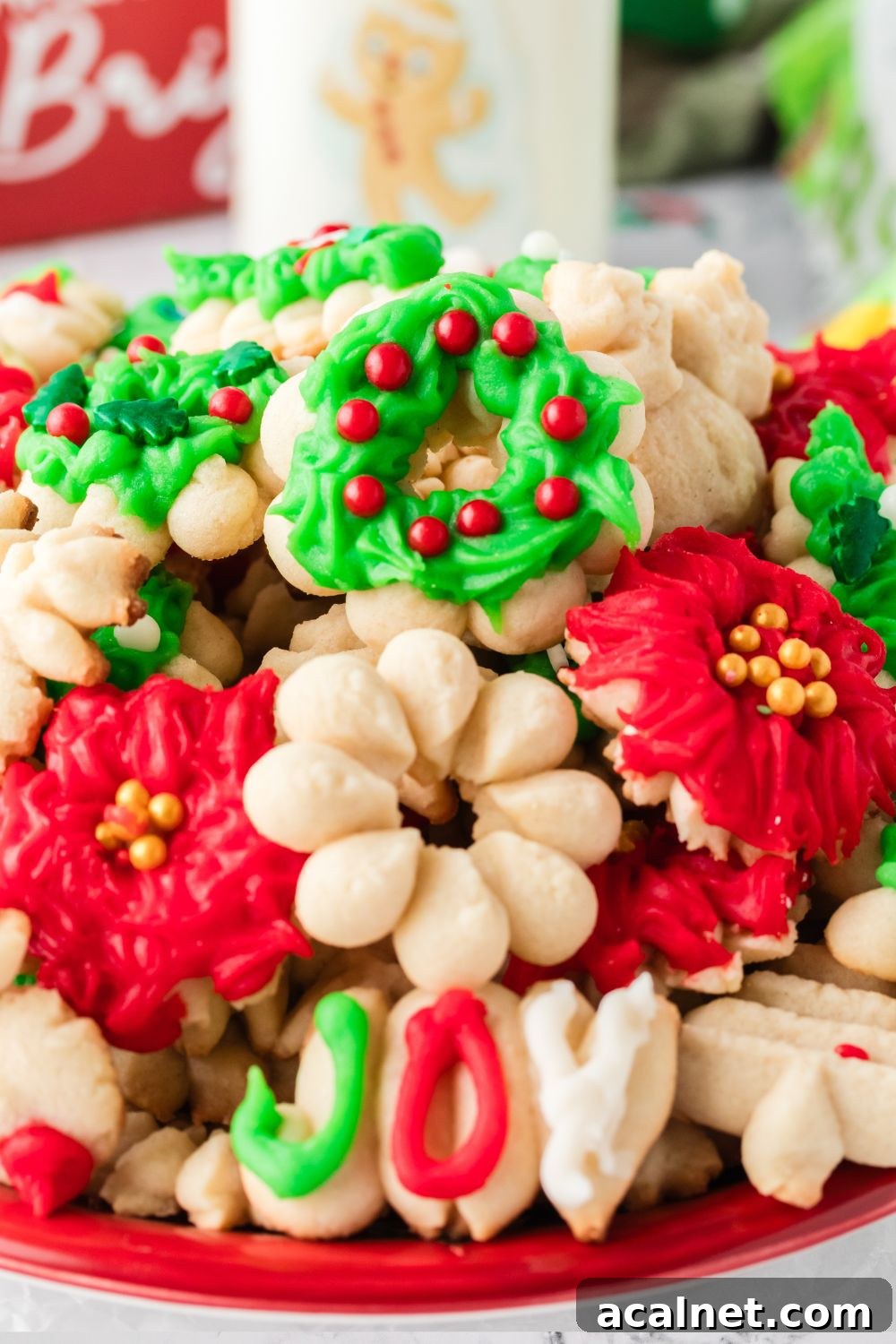 Classic Christmas Spritz Cookie Recipe 23 pressed cookies on a red plate on table