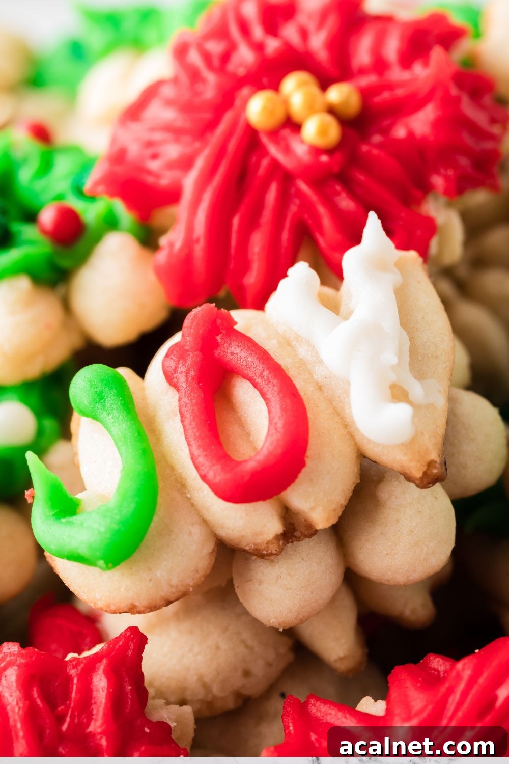 Classic Christmas Spritz Cookie Recipe 6 joy shaped cookie stacked on top of other cookies on tray