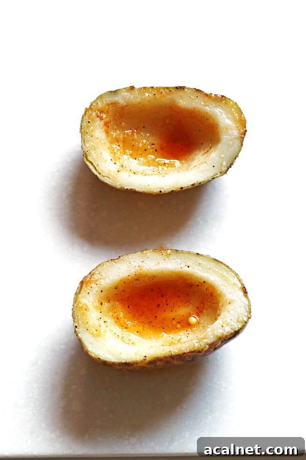 Potato skins cut in half, scooped out and covered with seasoning mixture.