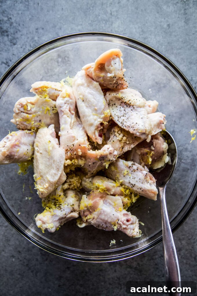 chicken wings marinating in a bowl with lemon garlic marinade