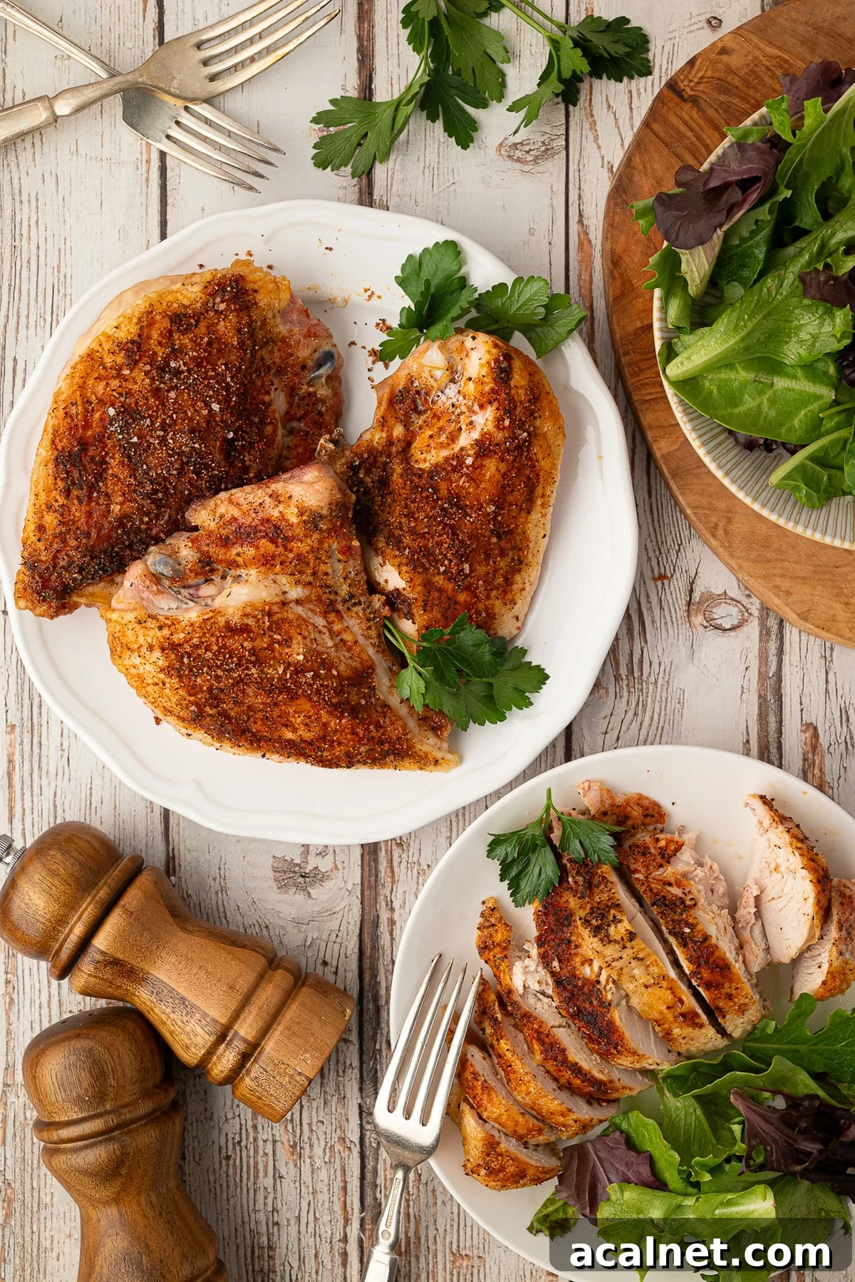 A plate of Texas dry rub seasoned bone-in split chicken breasts with perfectly crispy skin.