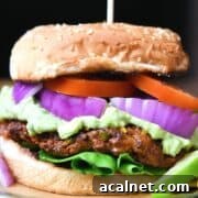 A venison burger piled with red onion, tomato, and lettuce