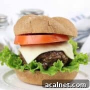 A venison burger piled with cheese, lettuce, and tomato