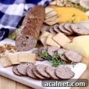 Venison summer sausage sliced and placed on a serving platter with crackers.