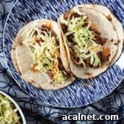 Two tacos made with ground venison on a blue plate