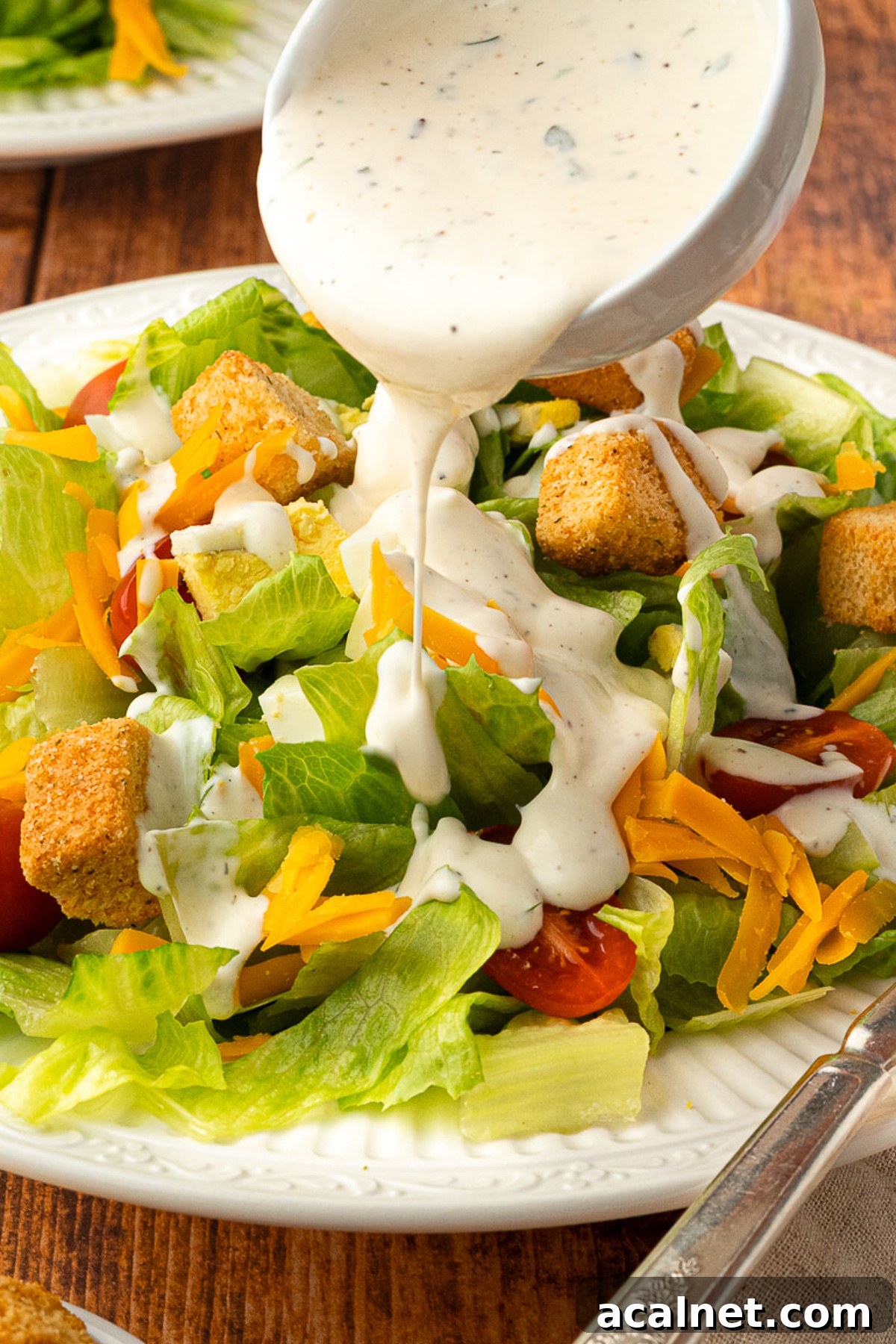 pouring buttermilk ranch dressing over roadhouse salad