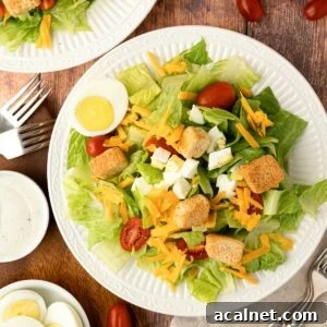 plated Texas Roadhouse Copycat Salad on white plate with ranch, croutons, eggs, tomatoes and lettuce
