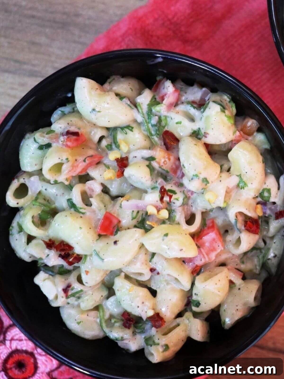 close-up of creamy macaroni salad in a black color bowl.
