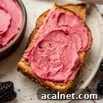 A photo of toast spread with homemade blackberry butter on a plate.