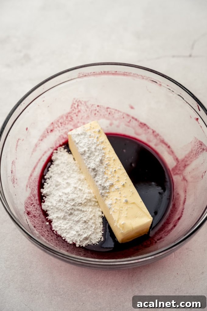 A glass bowl with blackberry juice, powdered sugar, and butter in it.