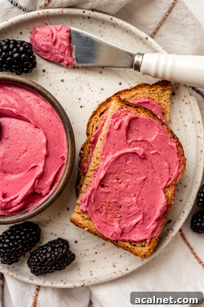 Aerial photo of blackberry butter in a bowl with a slice of toast that has some spread on it.