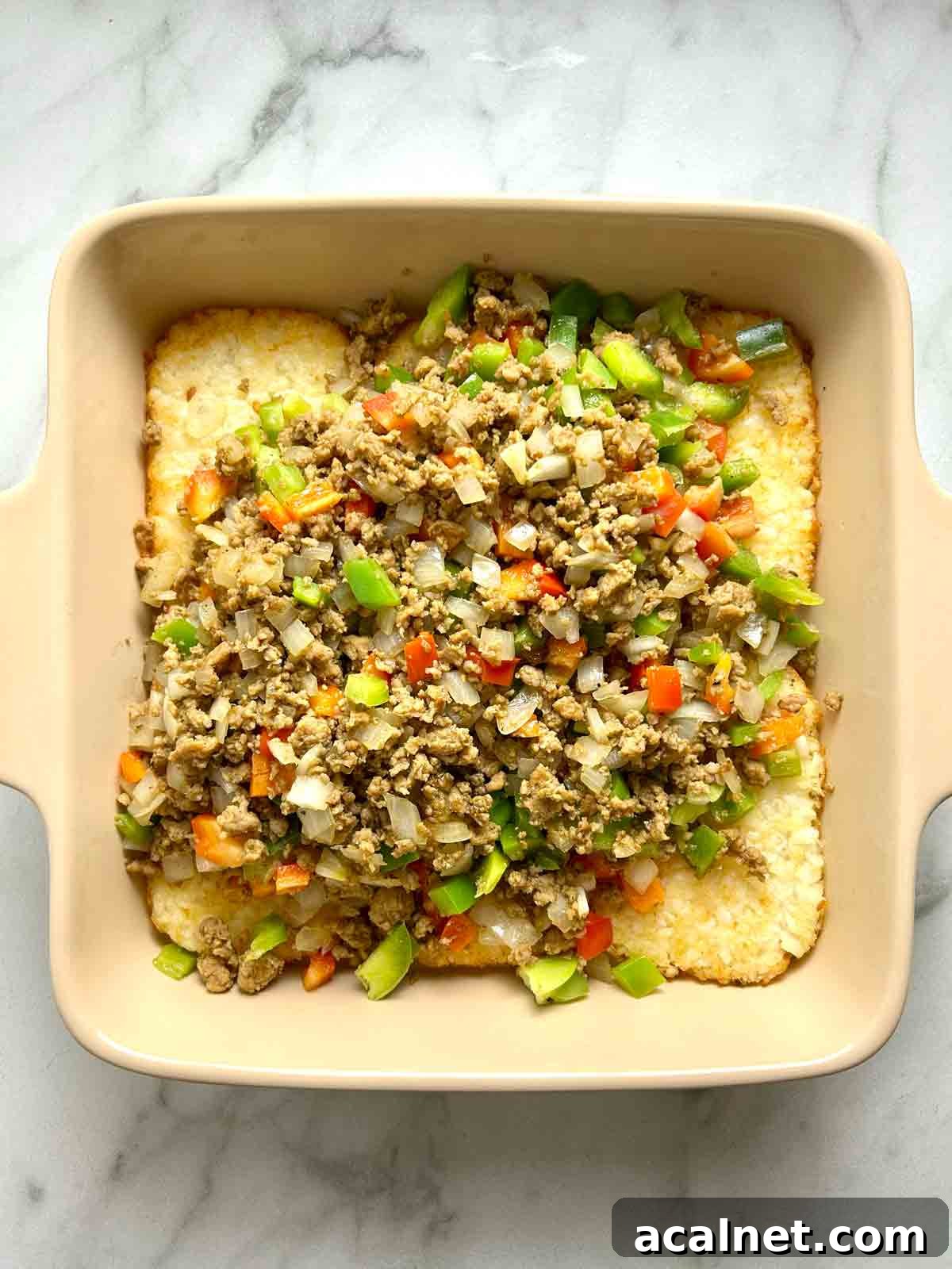Hearty Breakfast Casserole with Sausage and Cheese 7 sausage, onion, and bell pepper mixture poured on top of hashbrowns.