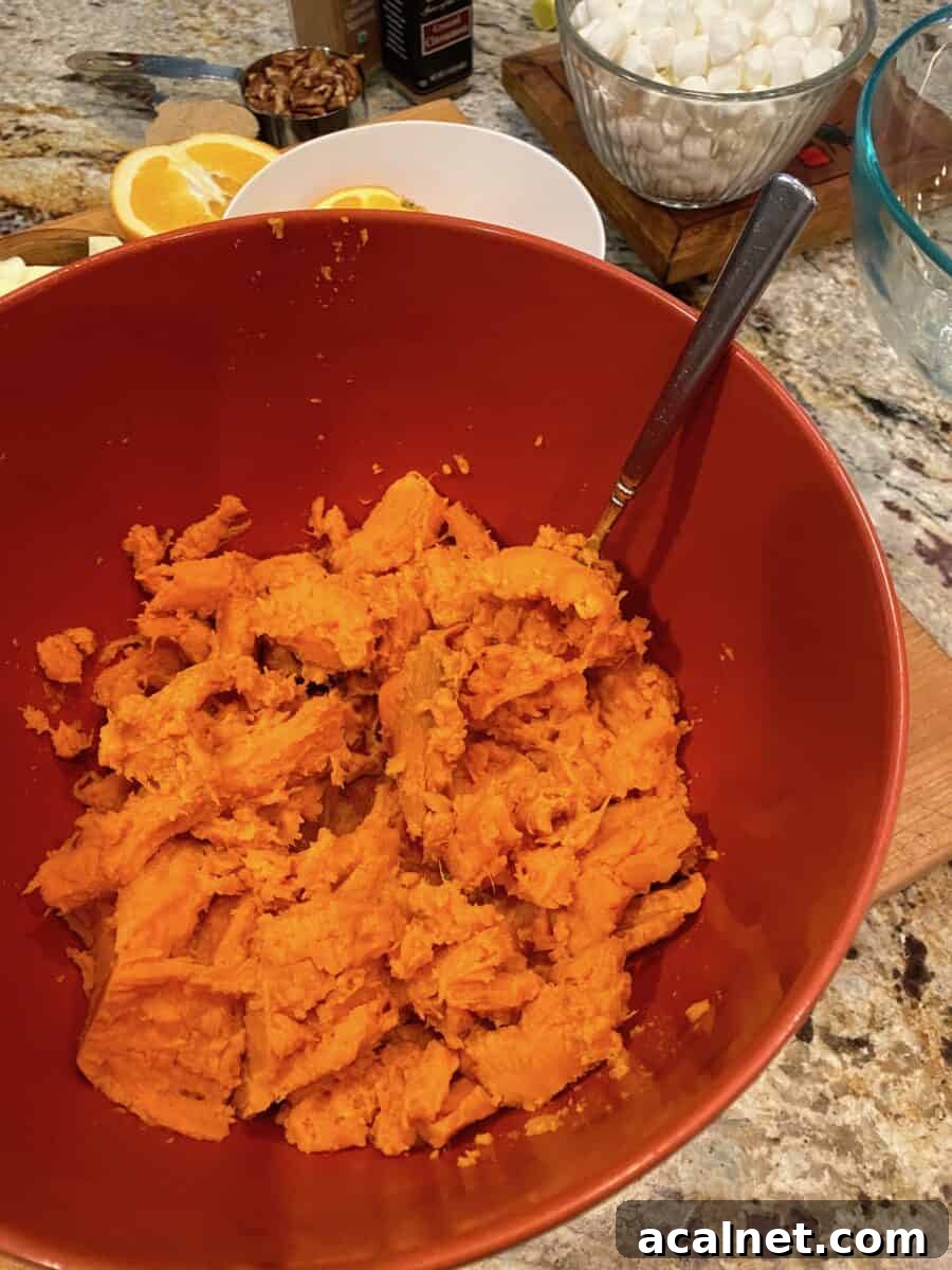 Mashed sweet potatoes in a bowl with a fork